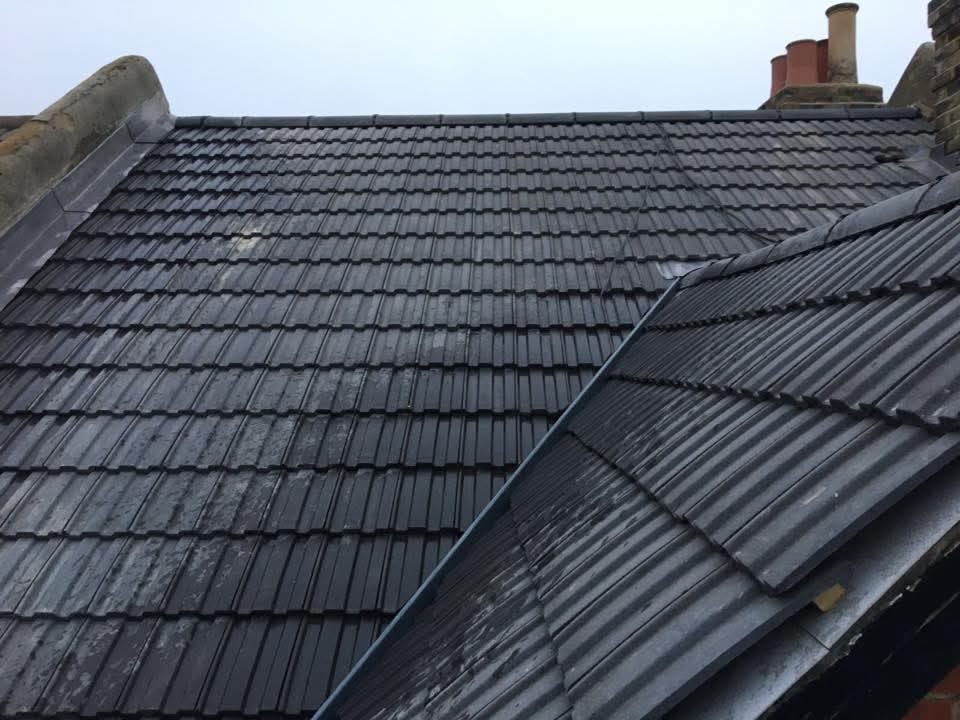 Roof replacement completed with clean new tiled surface and aligned flashing